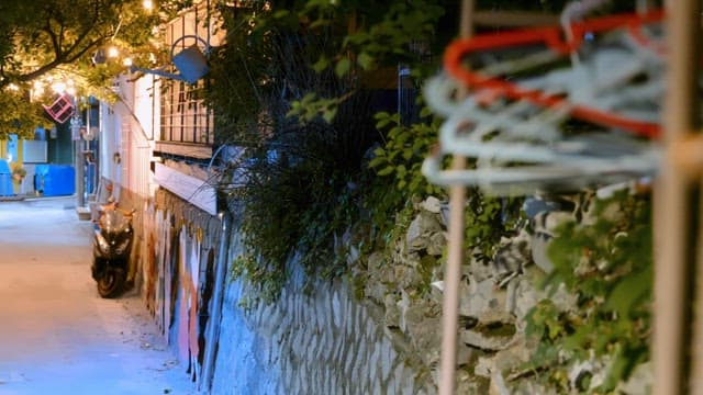 Quiet alley with a parked scooter at night