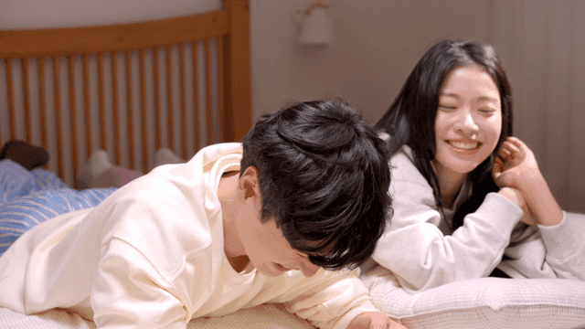 침대에서 누워 웃으며 대화하는 두 사람