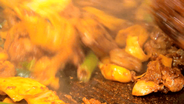 철판 위로 야채와 함께 볶아지는 닭갈비