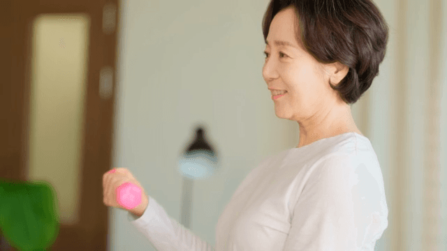 Woman exercising with a dumbbell indoors