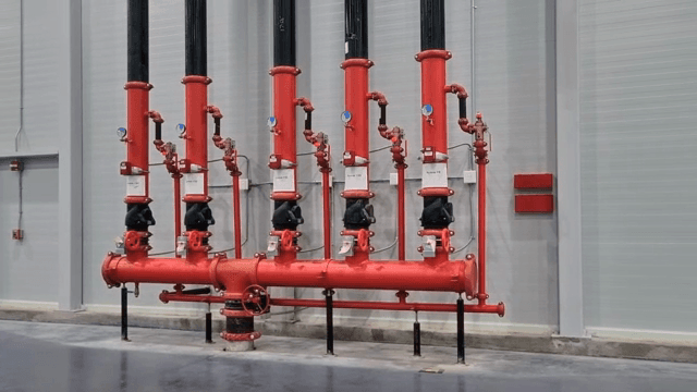 Red industrial pipes in a factory setting