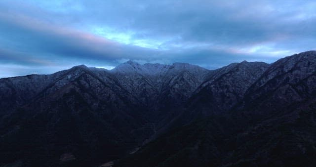 Snow-covered mountains under cloudy skies