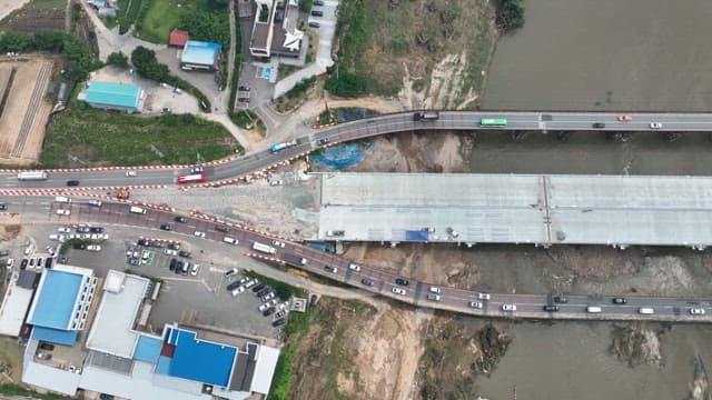 Aerial View of Vehicles Crossing a Straight Bridge