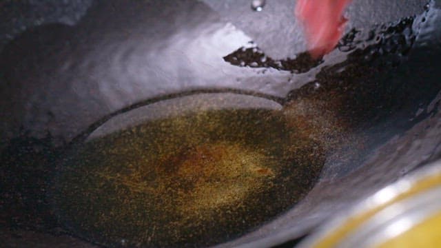 뜨거운 팬에 소고기 조각을 넣는 장면