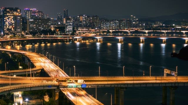 Night view of city bridges with moving traffic and high-rise buildings