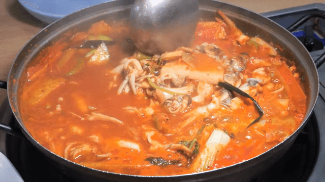 Spicy razor clam jjigae boiling in a pot