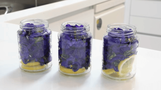 보라색 꽃과 레몬 조각이 담긴 병