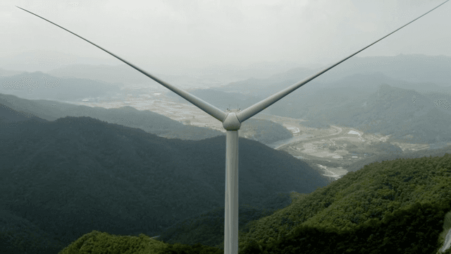 Wind turbine in a lush green mountain area