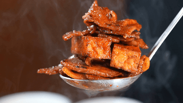 Spicy stir-fried pork scooped out with steaming ladle