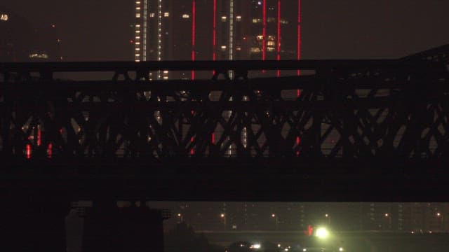 불빛이 켜진 고층 건물과 다리를 지나는 지하철이 만드는 야경