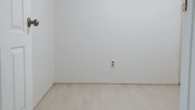 Empty room with a white door and outlet