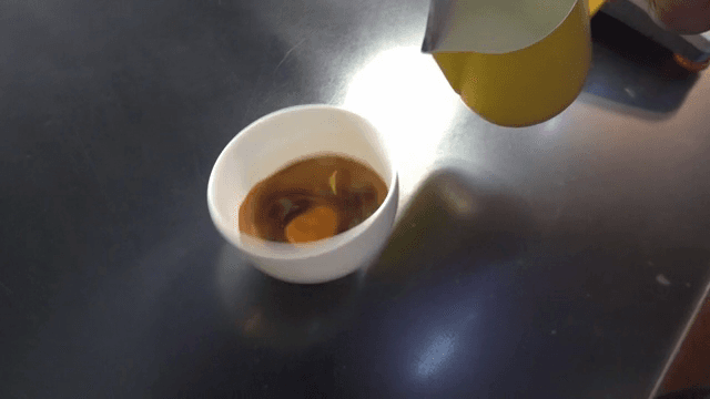 Pouring milk into a cup of espresso