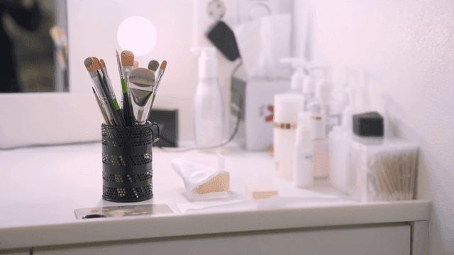 화장대 위의 메이크업 브러시와 스킨케어 제품