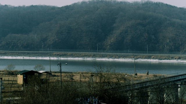 Serene Riverside with a Metallic Bridge