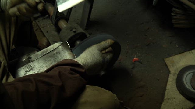 Worker sharpening a knife with sparks