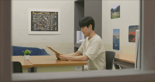 실내에서 봉투를 보는 남자