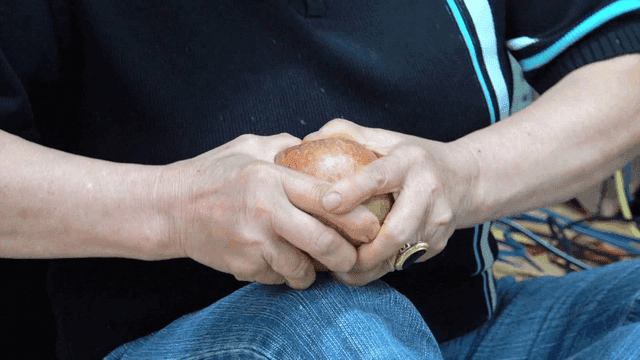 Person splitting apple in half with bare hands