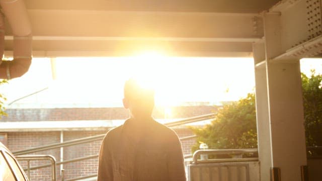 실내에서 햇빛을 받으며 서 있는 남자