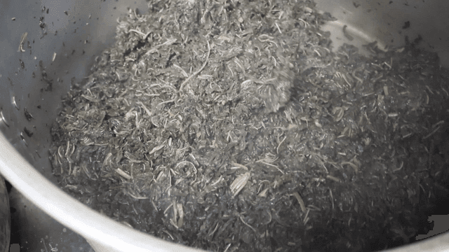 큰 나무주걱으로 아주까리를 볶고있는 요리사