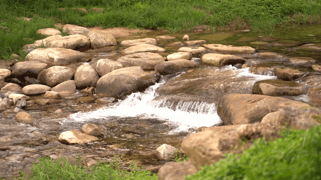 Small stream flowing between round stones"