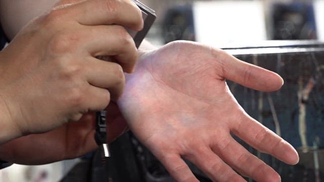 Fluorescent ink on the hand being illuminated by a UV lamp