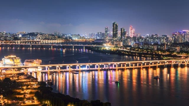 Night view of Seoul skyline with illuminated bridges and reflections