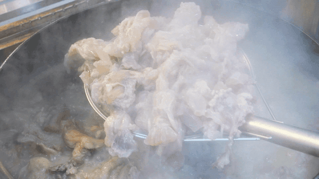 Beef tendon boiling in steaming pot