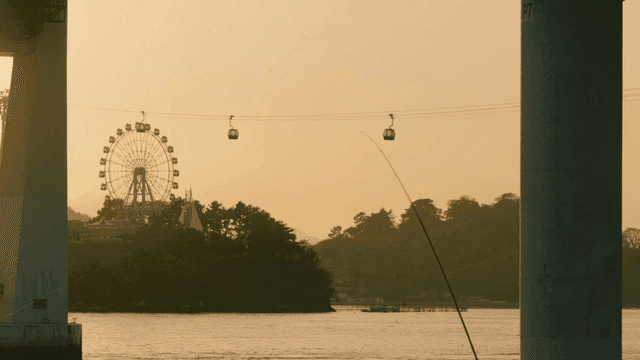 Ferris wheel and cable car in sunset sky