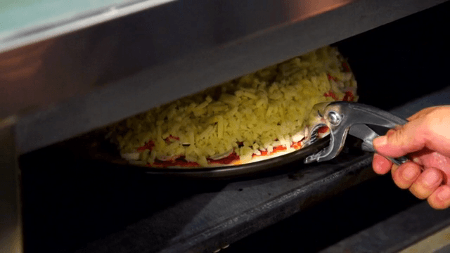 Pizza being placed into an oven