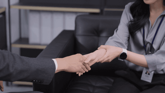 사무실에서 악수하는 두 동료