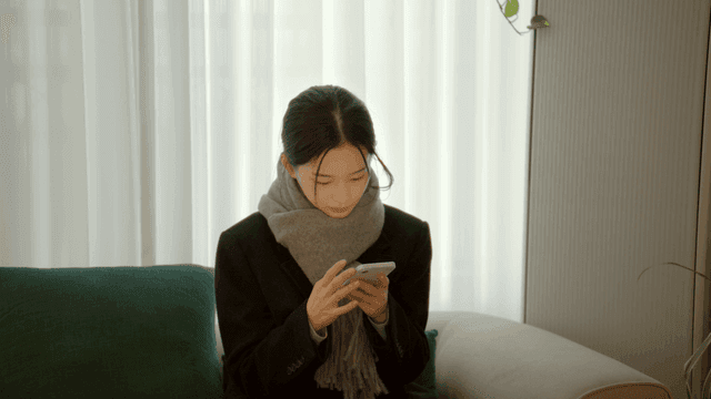 Woman using her smartphone in living room
