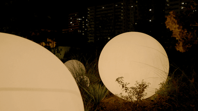 Glowing spheres in a city garden at night
