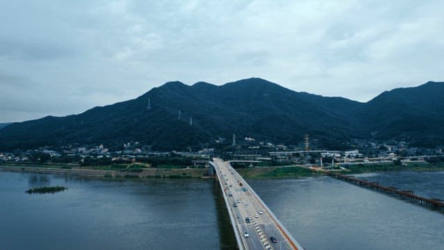 산이 보이는 넓은 강을 가로지르는 다리