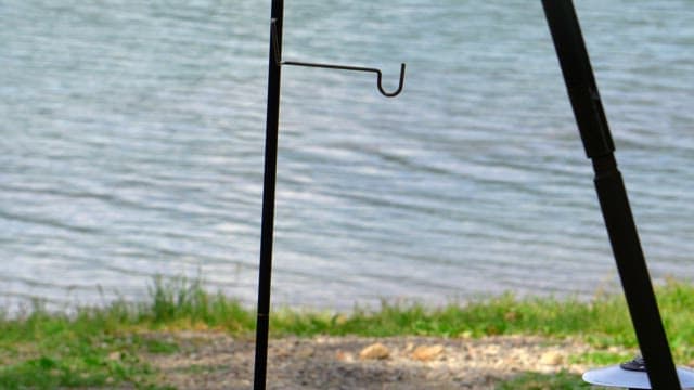 Setting up a camping lantern on the lakeside