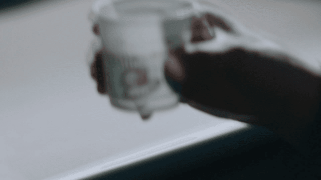 Person drinking mixed coffee from paper cup