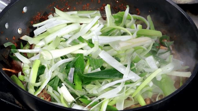 매운 양념 요리에 파를 올리는 모습