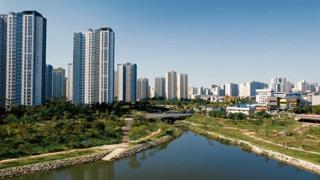 화창한 날 고층 아파트와 강이 있는 풍경