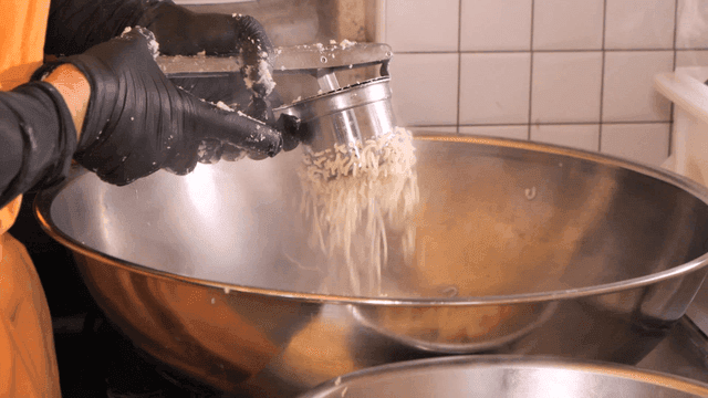 Chef pressing hot mashed potato masher