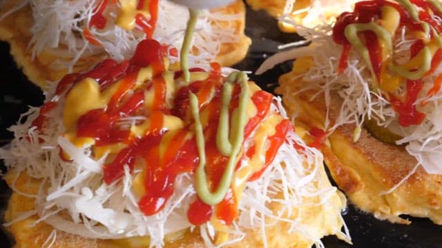 양배추 샐러드가 올라간 토스트 위에 소스를 뿌리는 모습