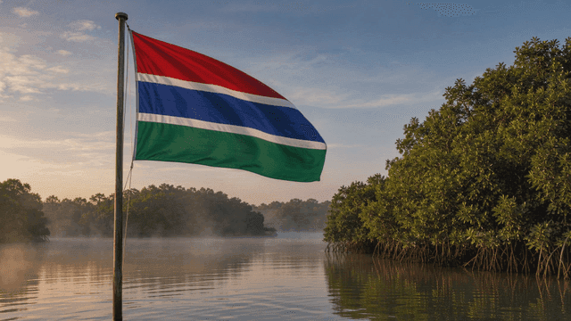 Gambian flag fluttering by quiet riverside