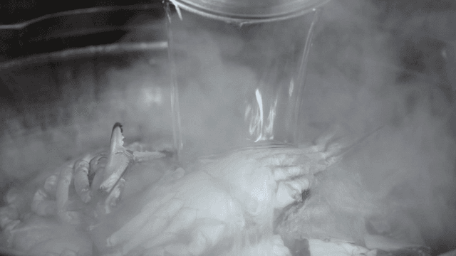 Hot water poured over crab in pot