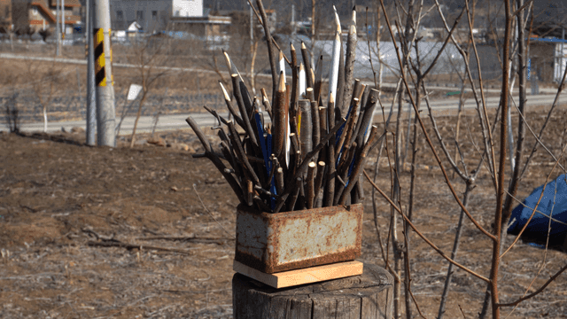 시골 배경의 나뭇가지 연필 조각품