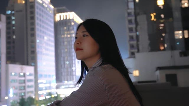 Woman gazing at city lights at night