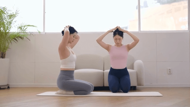 Yoga instructor guiding a student indoors