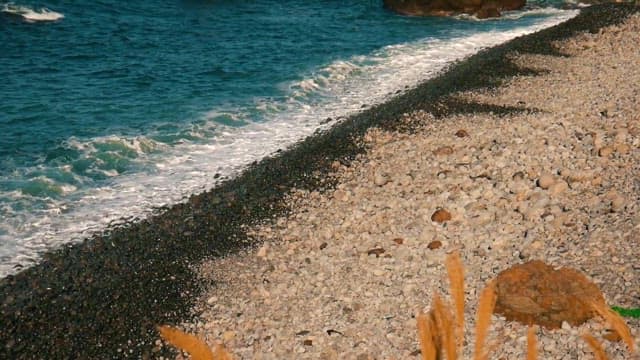 바위가 많은 자갈 해변에서 부서지는 파도