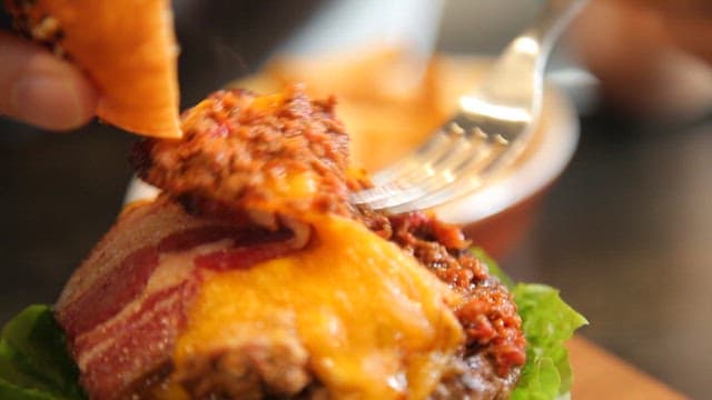 Savory beef patty topped with melted cheese and bacon in a burger