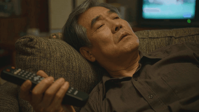 리모컨을 들고 소파에서 잠에 드는 노인