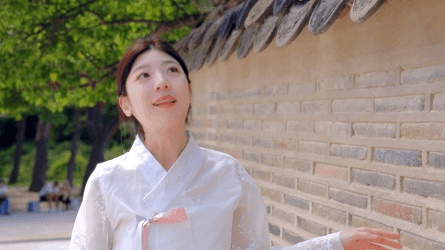 Woman in hanbok admiring traditional wall