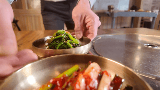 Seasoned greens and green onion kimchi served at table