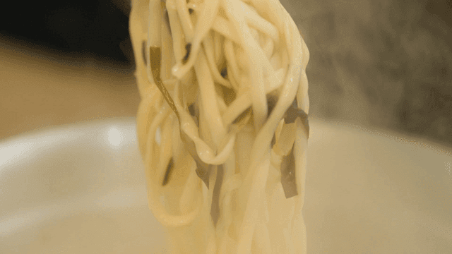Tongs lifting whole chicken kalguksu